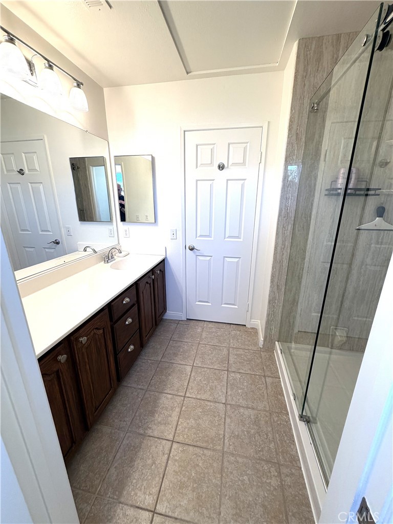 873 Greenridge Road Corona, CA 92882 - Photo 27 of 30 a bathroom with a granite countertop sink a toilet a mirror and vanity