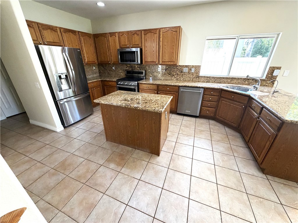 873 Greenridge Road Corona, CA 92882 - Photo 7 of 30 a kitchen with stainless steel appliances a sink a stove a microwave a counter top space and a window
