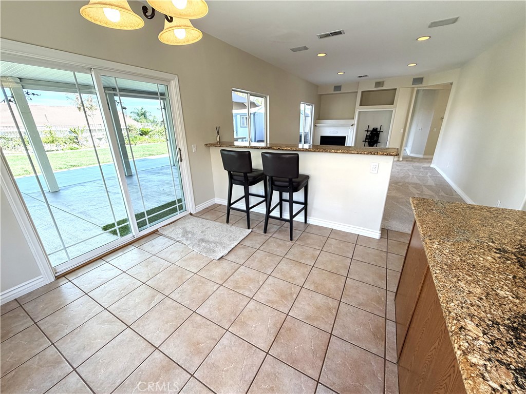 873 Greenridge Road Corona, CA 92882 - Photo 8 of 30 a view of a kitchen with kitchen island granite countertop refrigerator stove dining table and chairs