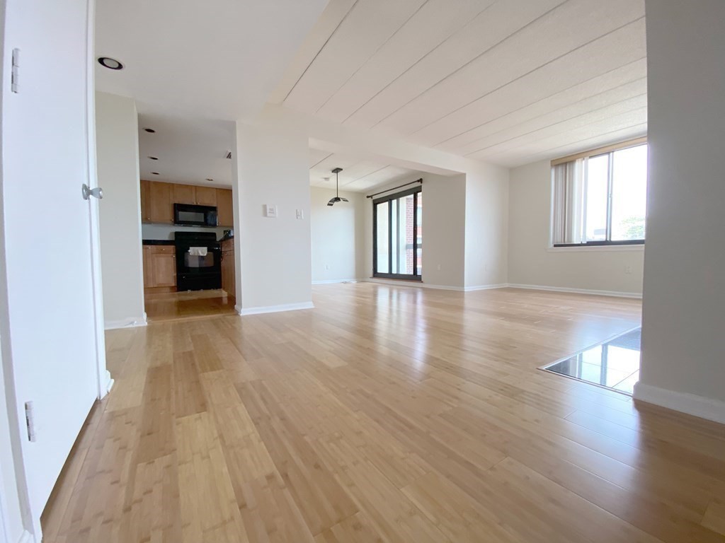 85 Brainerd Road, Unit 503 Boston, MA 02134 - Photo 6 of 21 a view of a big room with wooden floor and a window