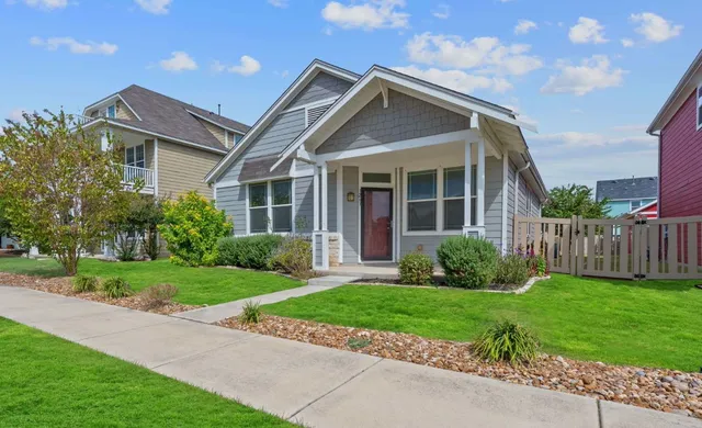 a front view of a house with a yard and potted plants