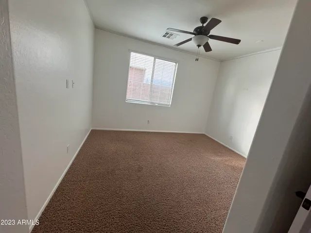 an empty room with a window and a fan