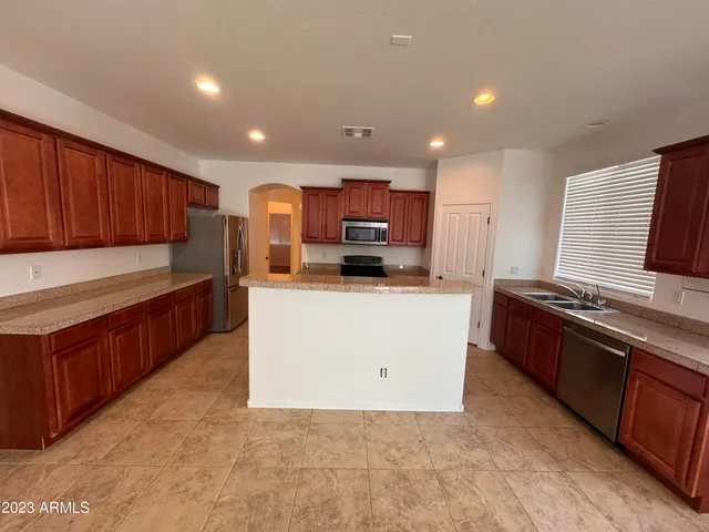 a large kitchen with stainless steel appliances and a stove top oven