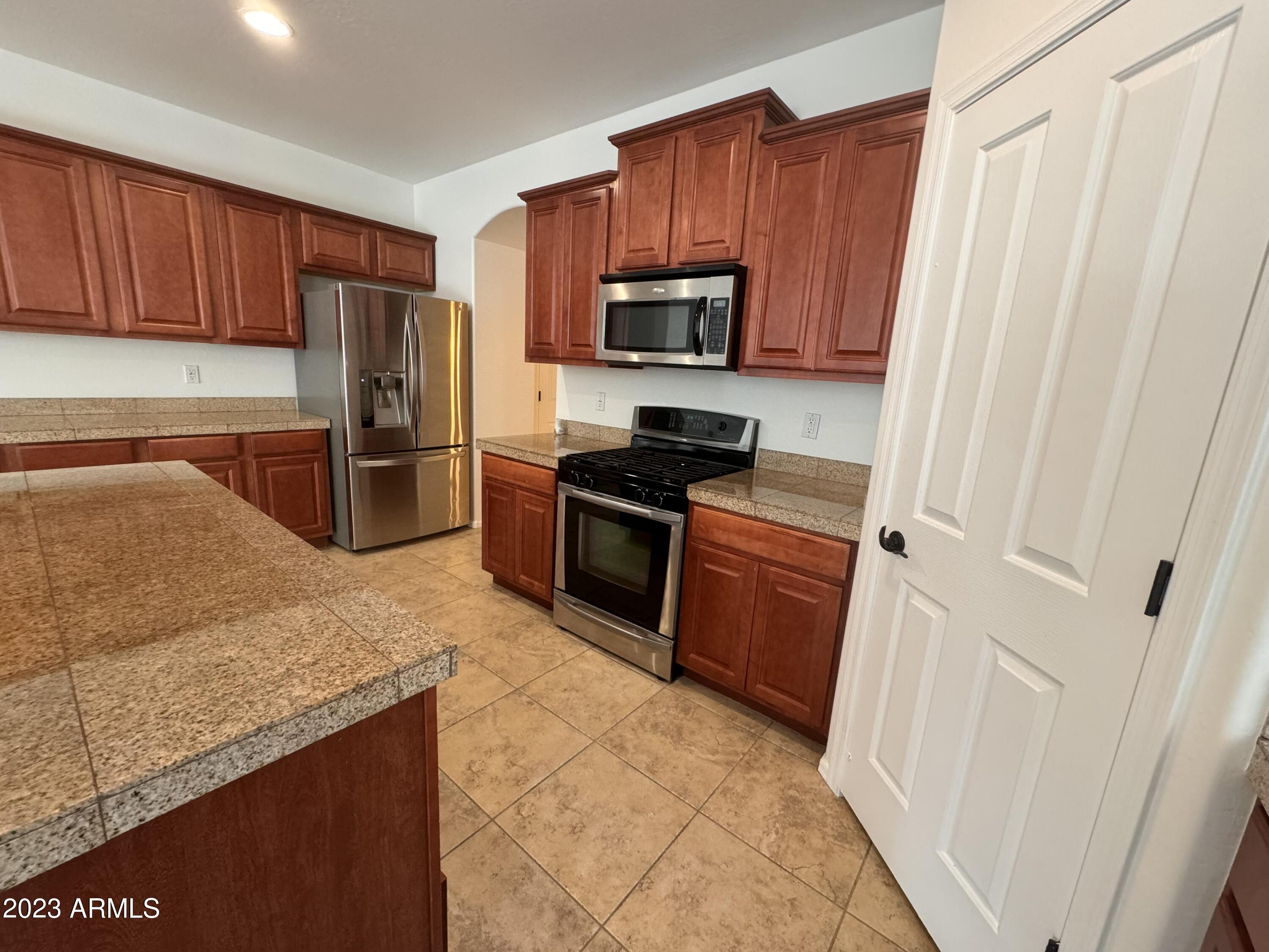 3753 East Phelps Street Gilbert, AZ 85295 - Photo 8 of 18 a kitchen with stainless steel appliances granite countertop a refrigerator stove and sink