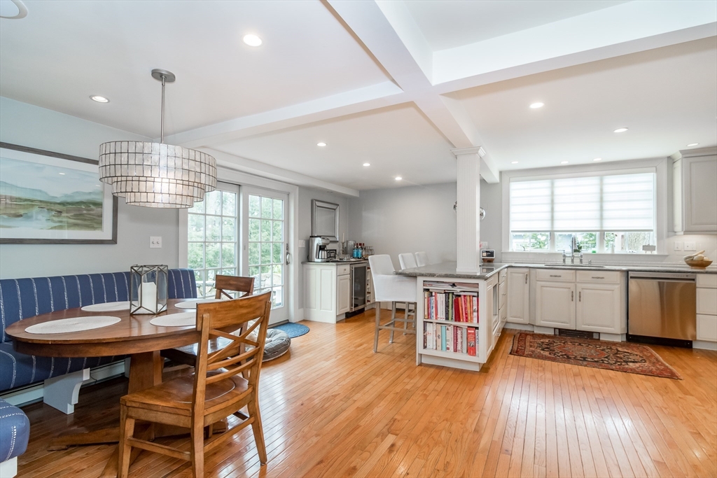 20 Colburn Road Wellesley, MA 02481 - Photo 13 of 31 a kitchen with stainless steel appliances granite countertop a stove top oven a sink a dining table and chairs with wooden floor