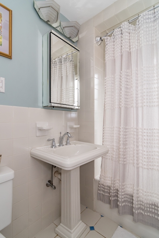 20 Colburn Road Wellesley, MA 02481 - Photo 19 of 31 a bathroom with a sink a mirror and a shower curtain