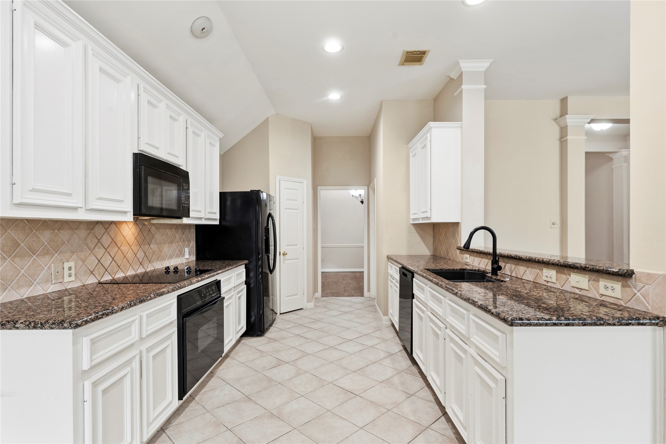 11619 Cedarvale Lane Tomball, TX 77377 - Photo 24 of 32 a large kitchen with granite countertop a sink and a stove top oven with wooden cabinets