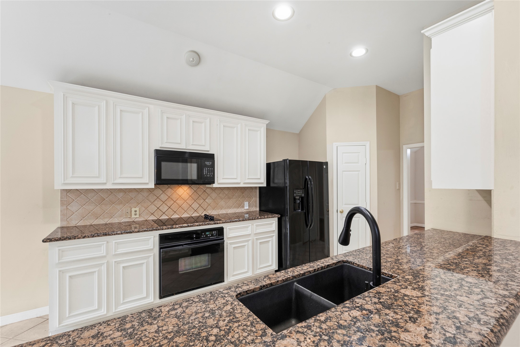 11619 Cedarvale Lane Tomball, TX 77377 - Photo 10 of 32 a kitchen with stainless steel appliances granite countertop a stove a sink dishwasher a refrigerator and white cabinets with wooden floor