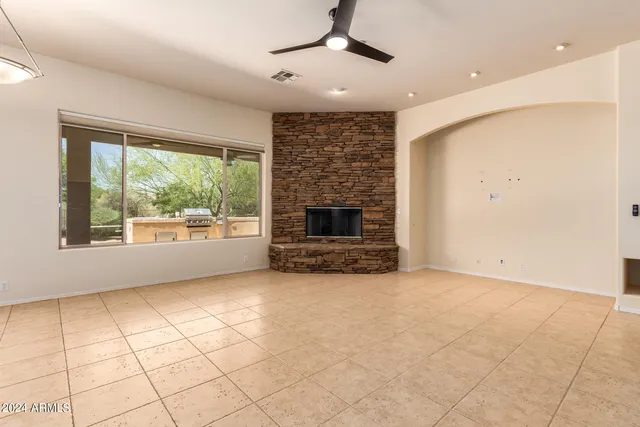 a view of empty room with fireplace and windows