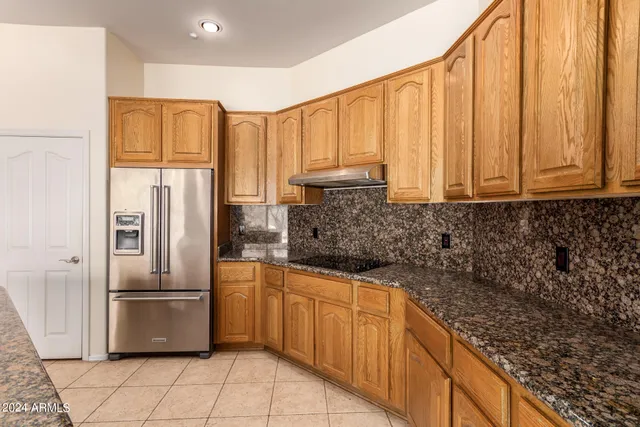 a kitchen with stainless steel appliances granite countertop a refrigerator and a sink