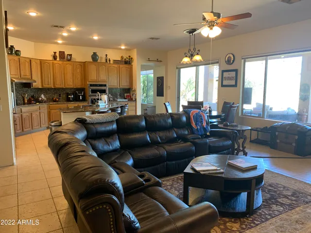 a living room with furniture kitchen view and a large window