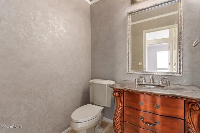 a bathroom with a toilet a sink and mirror