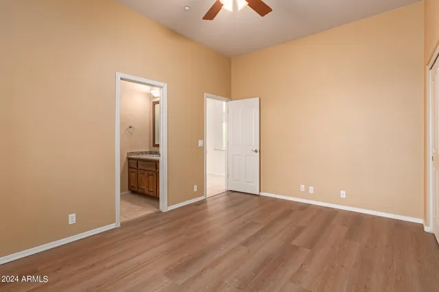 a view of a room with wooden floor and a kitchen