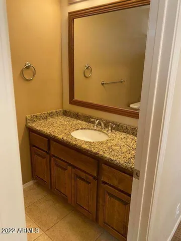 a bathroom with a granite countertop sink and a mirror
