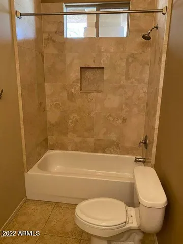 a bathroom with a toilet and a bath tub