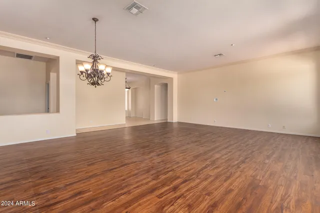 a view of a room with wooden floor chandelier and entryway
