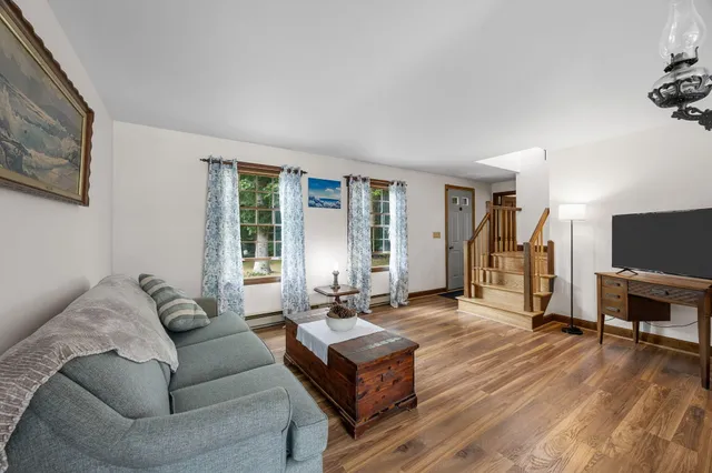 a living room with furniture dining table and wooden floor