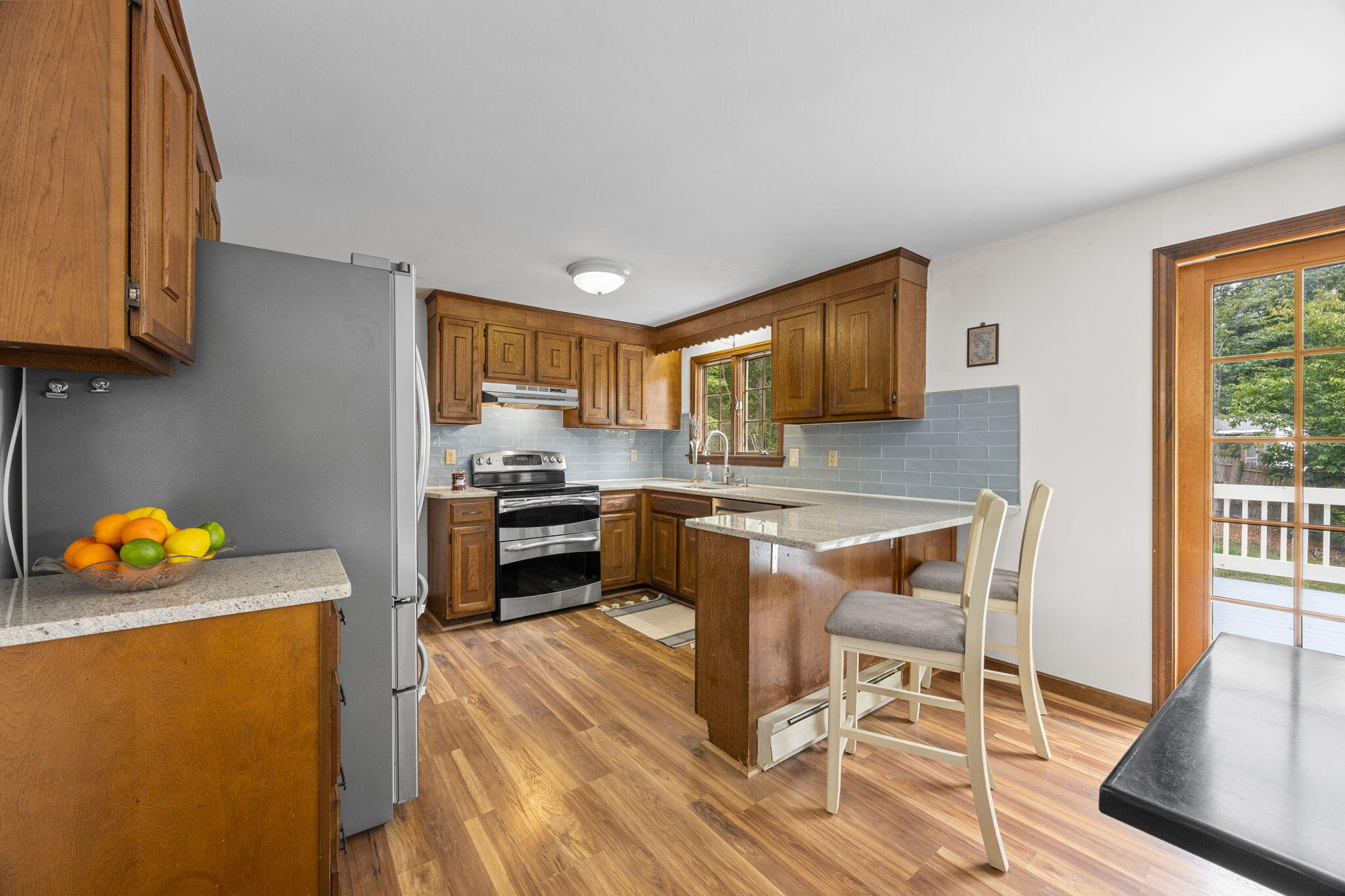 7 Horseshoe Circle Sandwich, MA 02563 - Photo 21 of 92 a kitchen with stainless steel appliances granite countertop a stove top oven a sink a dining table and chairs with wooden floor