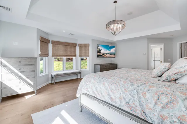 a bedroom with a large bed and a chandelier