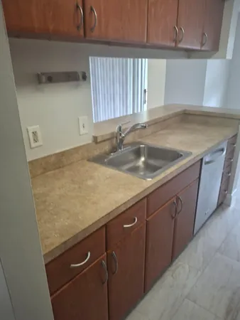 a kitchen with granite countertop sink and cabinets