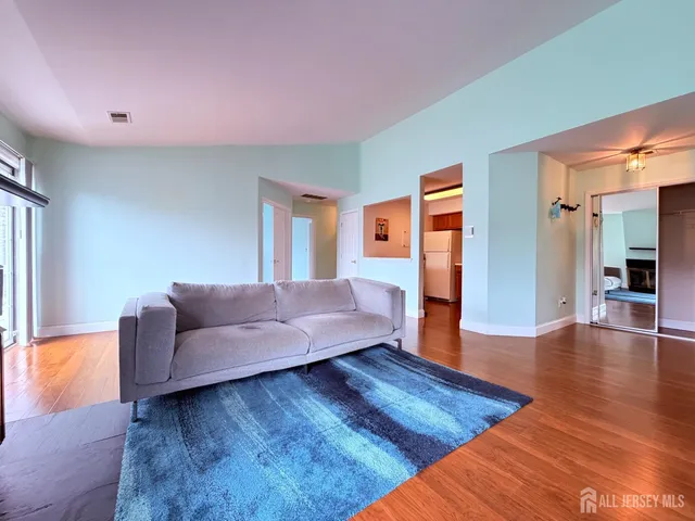 a living room with furniture and a wooden floor