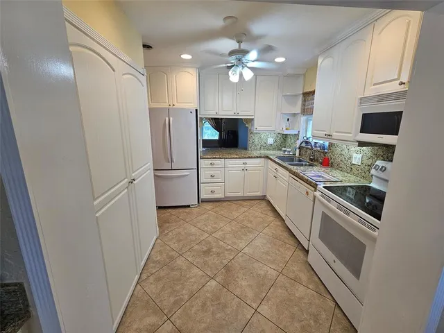 a large kitchen with a stove a refrigerator and a sink