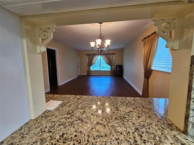 a view of a bedroom with wooden floor and chandelier