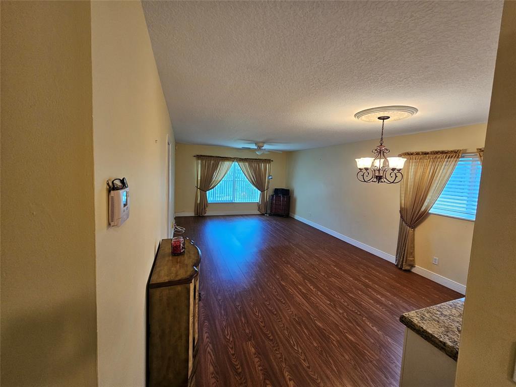 6650 Royal Palm Boulevard, Unit 315C Margate, FL 33063 - Photo 7 of 17 a view of a room with wooden floor chandelier and windows