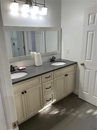 a bathroom with a granite countertop sink and a mirror