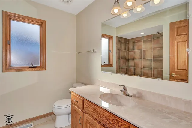 a bathroom with a granite countertop sink mirror vanity and toilet