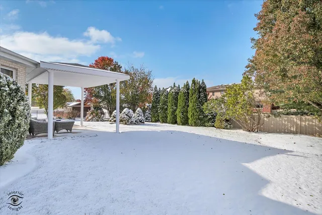 a view of a patio with table and chairs under an umbrella