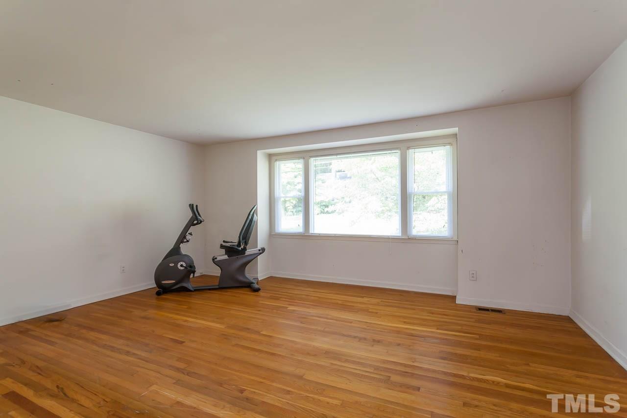 2252 Rumson Road Raleigh, NC 27610 - Photo 7 of 20 a view of a room with wooden floor air conditioner and windows