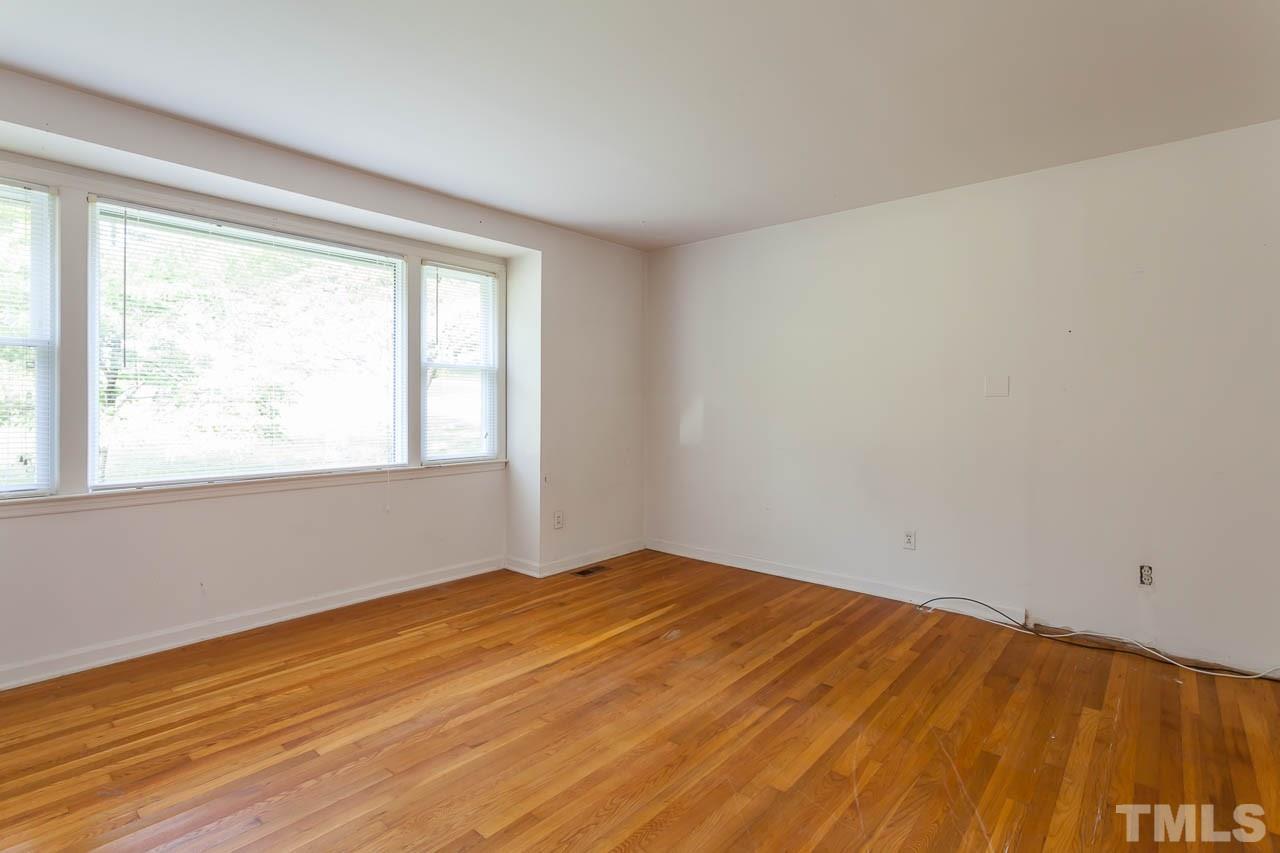 2252 Rumson Road Raleigh, NC 27610 - Photo 10 of 20 a view of empty room with wooden floor and fan