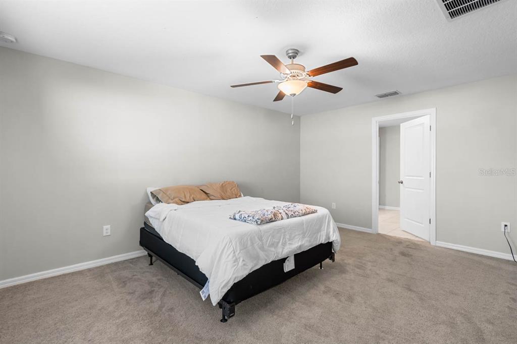 889 Calico Scallop Street Ruskin, FL 33570 - Photo 14 of 37 a bedroom with a bed and a ceiling fan