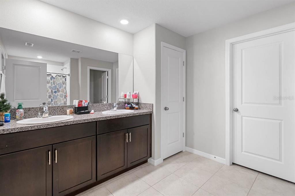889 Calico Scallop Street Ruskin, FL 33570 - Photo 15 of 37 a bathroom with a double vanity sink and a mirror