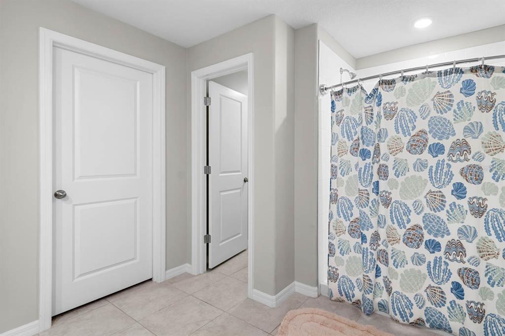889 Calico Scallop Street Ruskin, FL 33570 - Photo 16 of 37 a bathroom with a shower curtain and a shower curtain
