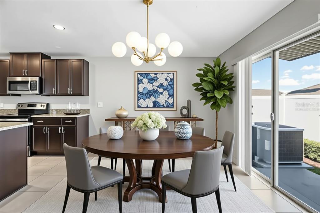 889 Calico Scallop Street Ruskin, FL 33570 - Photo 8 of 37 a dining room with wooden floor a chandelier a wooden table and chairs