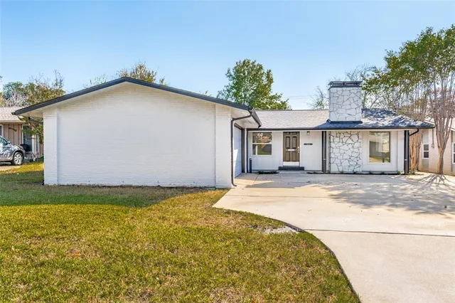a view of a white house with a yard and garage