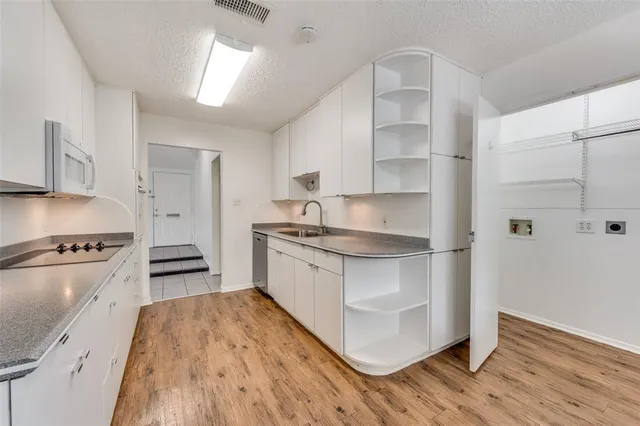 a kitchen with granite countertop white cabinets and white appliances