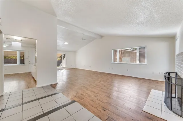 a view of a hallway with wooden floor and a living room