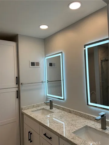 a bathroom with a granite countertop sink and a mirror