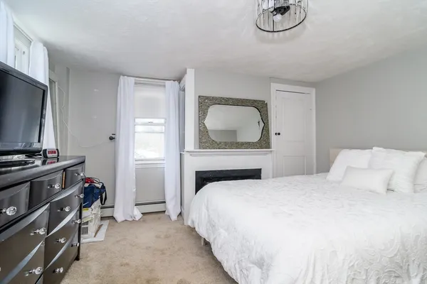 a bedroom with a bed and a flat tv screen on the dresser