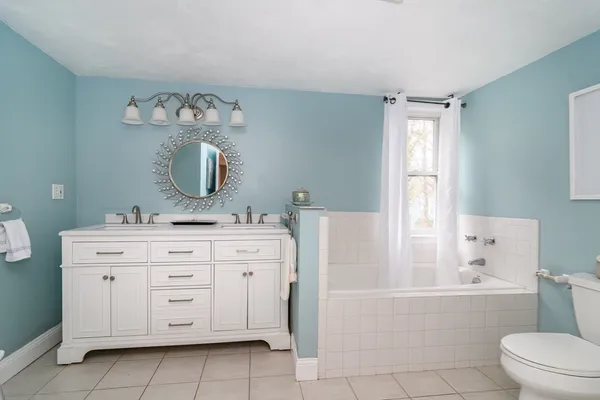 a bathroom with a bathtub sink and mirror