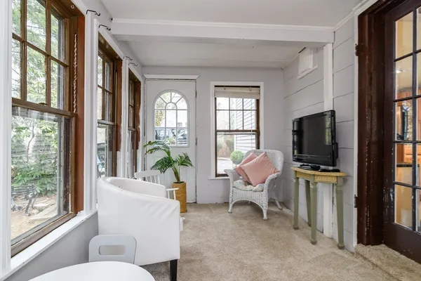 a living room with furniture a flat screen tv and a floor to ceiling window
