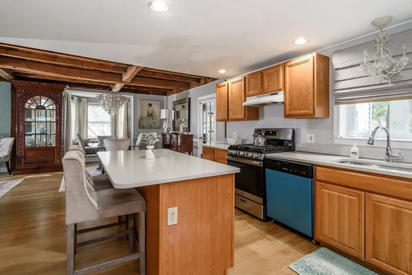 a kitchen with kitchen island granite countertop a sink cabinets and stainless steel appliances