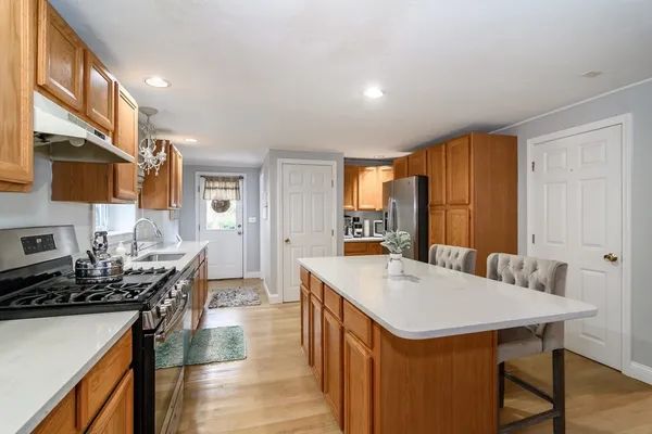 a kitchen with a stove a refrigerator a sink a dining table and chairs