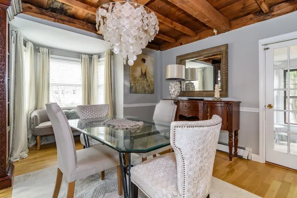 a dining room with furniture a chandelier and wooden floor