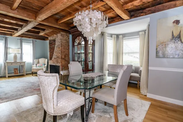 a dining room with furniture a chandelier and wooden floor