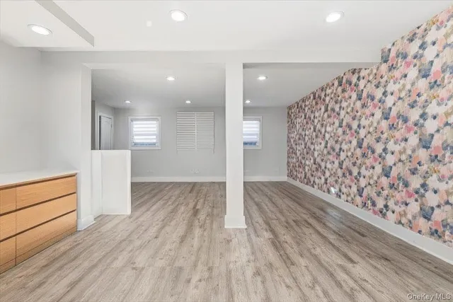 an empty room with wooden floor and white walls