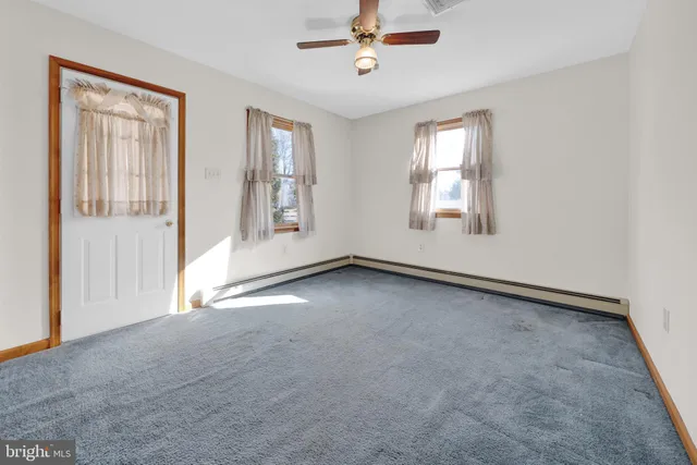 an empty room with windows and painted walls